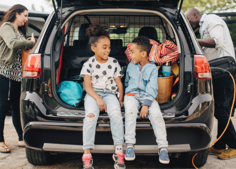 family loading car for trip with kids in the center
