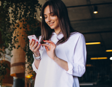 woman smiling while looking at phone